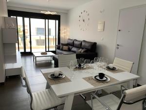 una sala da pranzo e un soggiorno con tavolo e sedie. di Casa Higuericas- Penthouse Beach - Torre de la Horadada a El Mojón