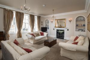 a living room with two white couches and a fireplace at Lady Margaret's in Bath