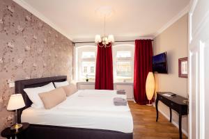 1 dormitorio con 1 cama grande y cortinas rojas en Ferienwohnung Gründerhaus, en Brandenburg an der Havel