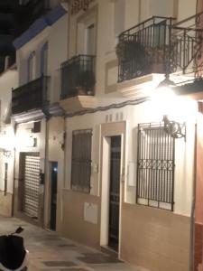 a building with balconies and a cat sitting in front of it at Fuengirola Holidays Sun & Beach in Fuengirola