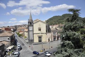 an old building with a clock tower in a city at Casa al Centro Storico in Nicolosi