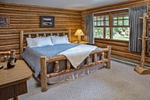 um quarto com uma cama num chalé de madeira em Stanley High Country Inn em Stanley