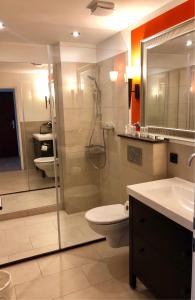 a bathroom with a shower and a toilet and a sink at Hotel Ramor Garni in Duisburg