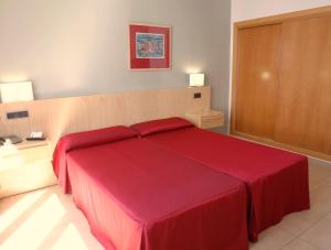 a bedroom with a large red bed in a room at Hotel Adiafa in Barbate