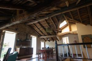 a living room with wooden ceilings and a table at CASA PELTRE in Sarria