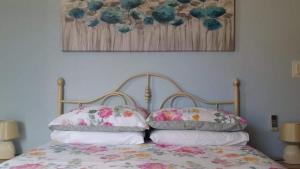 een bed met twee kussens en een foto aan de muur bij Comfort Apartment No. 16, Daffodil Court in St Paul's Bay
