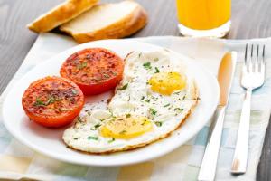 a plate of eggs and tomatoes on a table at Hotel Hollywood in Kutaisi