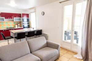 a living room with a couch and a kitchen at F2 cozy proche paris, aéroport CDG in Clichy-sous-Bois