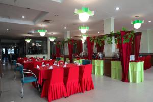a dining room with red and green tables and chairs at Super OYO 742 Mona Plaza Hotel in Pekanbaru