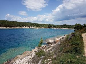 a body of water with a beach in the background at Apartman Suzy in Pula