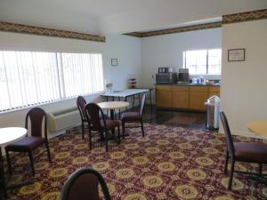 a room with a table and chairs and a kitchen at Executive Inn & Suites West Columbia in West Columbia