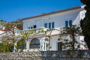 a white house behind a stone wall at Apartment Kata in Sveti Juraj