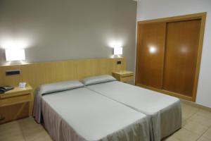 a bedroom with a large white bed and two night stands at Hotel Adiafa in Barbate