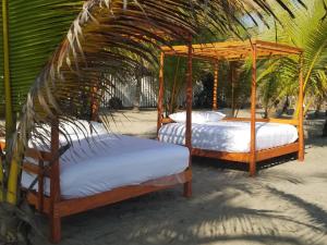 プラヤ・アスールにあるNichos Beach Villasのガゼボの下に座って2台のベッド