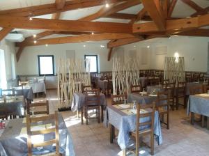 uma sala de jantar com mesas e cadeiras e tectos em madeira em Terrasses de l'Aven em Orgnac-lʼAven