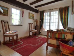 a living room with two chairs and a red rug at Maison d'hôtes de charme ttakoinenborda in Sare