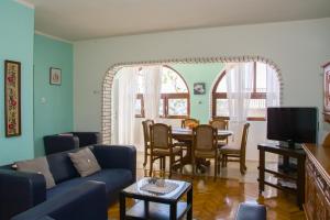 ein Wohnzimmer mit einem blauen Sofa und einem Tisch in der Unterkunft Apartment Kata in Sveti Juraj