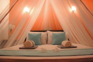 a bed with two hats and pillows on it at The Courtyard Villa in Sigiriya