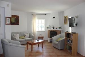 a living room with two couches and a tv at Nightingale Villa in Albufeira