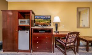 a room with a desk with a microwave and a refrigerator at Hotchkiss Inn Motel in Hotchkiss