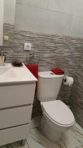 a bathroom with a white toilet and a sink at BEAUTIFUL SMALL APARTAMENT in Costa Calma
