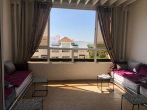 a room with two couches and a large window at Asilah Marina Golf A3 in Asilah
