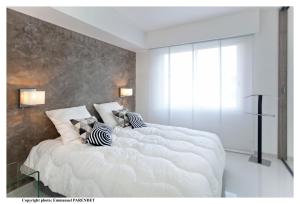 Beautiful modern apartment in La Croisette with sea view في كان: غرفة نوم بسريرين كبار بيض مع مخدات