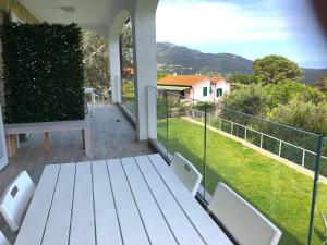 マルチャーナ・マリーナにあるCountry House Tagliaferroの白いテーブルと椅子、景色を望むバルコニー