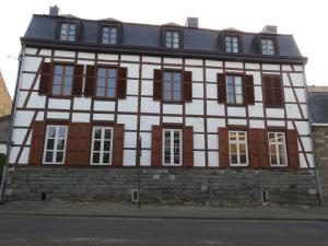 una casa antigua con ventanas marrones y blancas en LA DILIGENCE en Jalhay