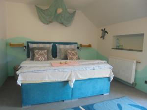 a bedroom with a blue bed in a room at Penzion Šerhant in Zahořánky