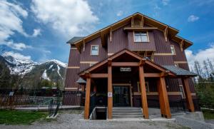 a large wooden building with mountains in the background at Timberline by FantasticStay in Fernie