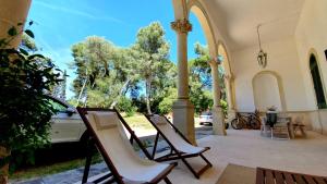聖塔卡特林納迪納爾多的住宿－Villa Giulio B&B DImora Storica，两把椅子坐在房子的门廊上