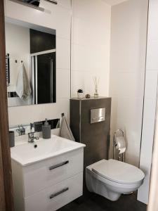 a white bathroom with a toilet and a sink at Casa de Rosa in Zator