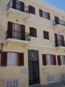 a building with a black door and balconies at Nautilos in Tinos