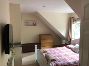 a bedroom with a bed and a tv at Rose Cottage in Inverness