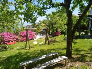 モウレシにあるArchontiko Iatridisのベンチ付きの公園、ピンクの花が咲く遊び場