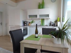 Una botella de vino sentada en una mesa de madera en la cocina en York Cottage Heaven, en Traben-Trarbach