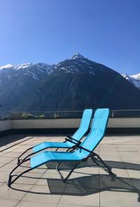 a blue chair sitting on a roof with a mountain at Das Haus Kunz in Imsterberg