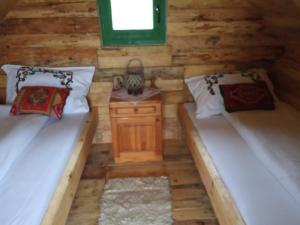 a room with two beds in a log cabin at Bungalovi Mijakovici in Pljevlja