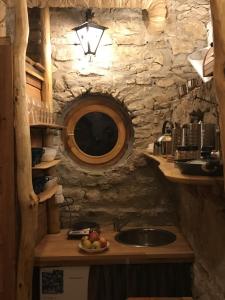 a kitchen with a sink and a stone wall at Fűtetős Dombház in Üröm