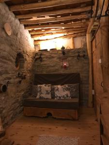 een kamer met een bed in een stenen muur bij Fűtetős Dombház in Üröm