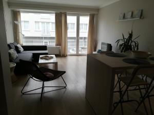 - un salon avec un canapé et une table dans l'établissement appartement oostende vlak bij zee, à Ostende
