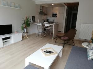 een woonkamer met een bank en een tafel bij appartement oostende vlak bij zee in Oostende