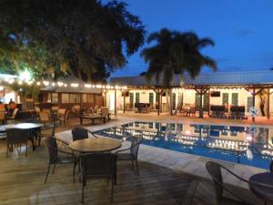 Casey Key Resorts - Mainland في Osprey: فناء به طاولات وكراسي بجانب مسبح