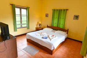 1 dormitorio con 1 cama con 2 toallas en Krathom Khaolak Resort, en Khao Lak