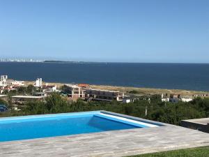a swimming pool with a view of the ocean at Syrah Vistas Punta Ballena in Punta del Este