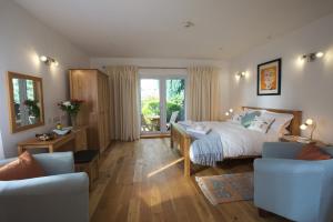 a bedroom with a bed and a desk and chairs at Seascape at coed y berclas in Llandegfan