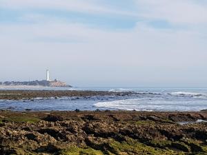 a beach with a lighthouse in the distance at Residencial La Teja in Zahora