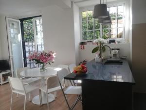 uma cozinha com uma mesa branca e cadeiras brancas e uma mesa com flores em Apartment Carvalho Araujo em Cascais