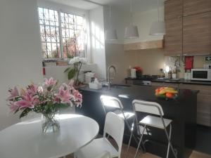 uma cozinha com uma mesa com um vaso de flores em Apartment Carvalho Araujo em Cascais